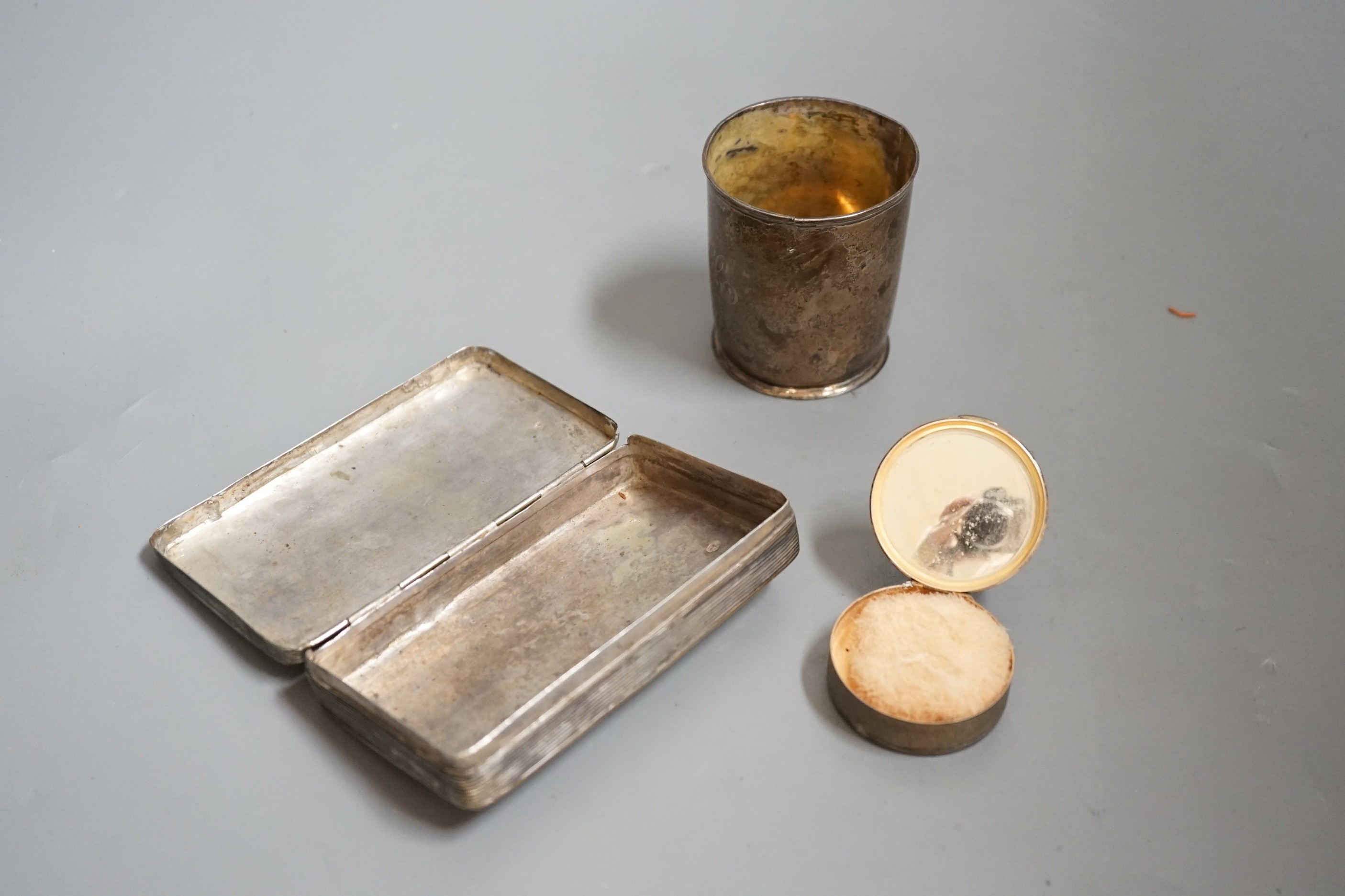 A Dutch white metal tobacco box, 11.3cm and a similar beaker (both a.f.) together with a French engine turned white metal circular compact.